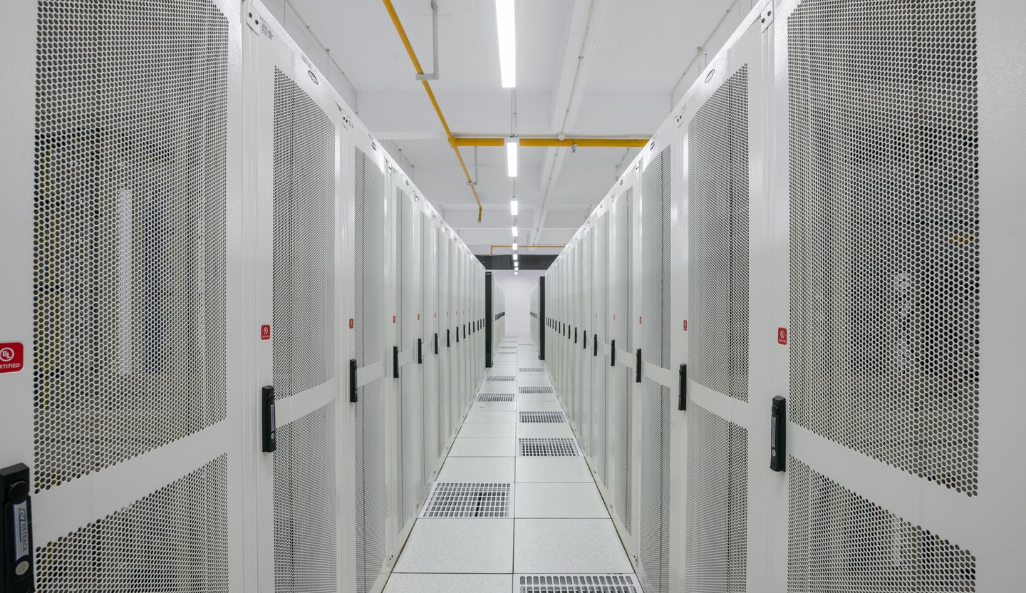Rows of servers inside a modern data center, the compute layer of the AI stack